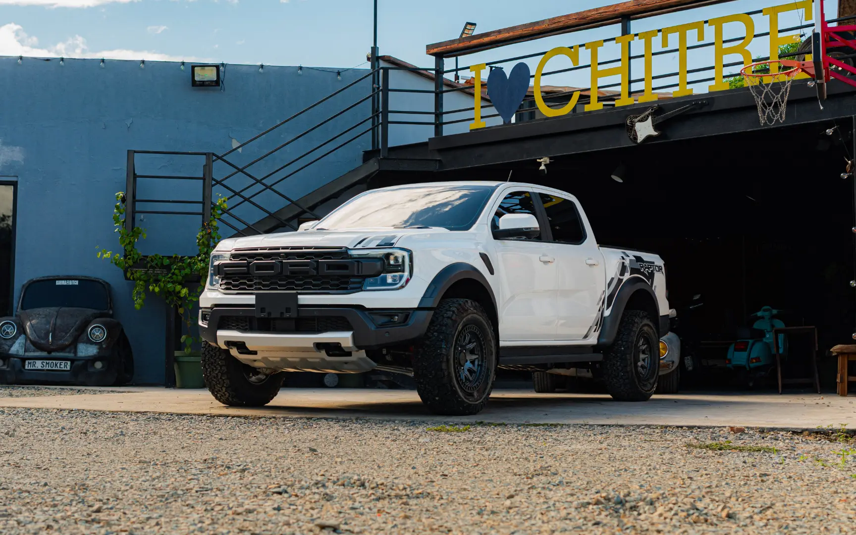 Camioneta pick-up Ford Raptor blanca estacionada frente a un local con letrero de Chitré.